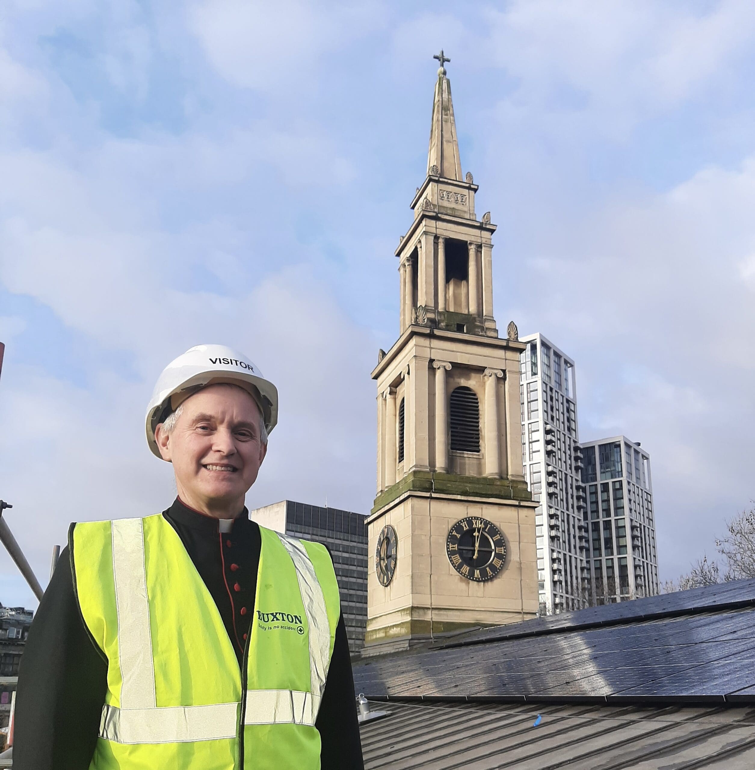 Canon Giles Goddard on the roof of St John's next to solar panels